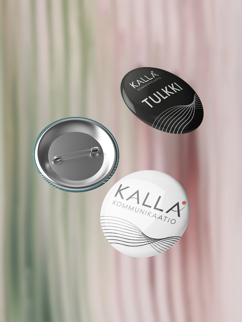 Kalla Kommunikaation rintamerkit tulkeille. Toinen mustalla ja toinen valkoisella pohjalla, jossa logo ja mustassa teksti tulkki.